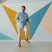 Modern guy is listening to radio through headphones dancing on colorful background alone enjoying music at home. Technology and lifestyle concept.