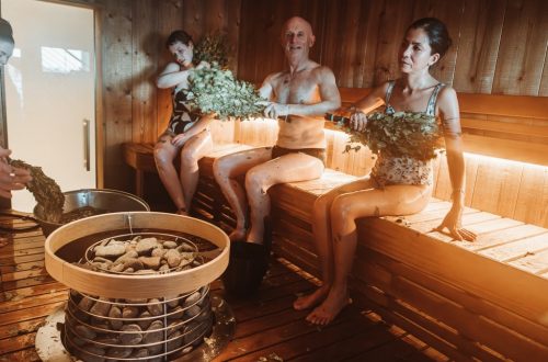 Group of people enjoying a traditional Nordic sauna with natural sauna whisking.